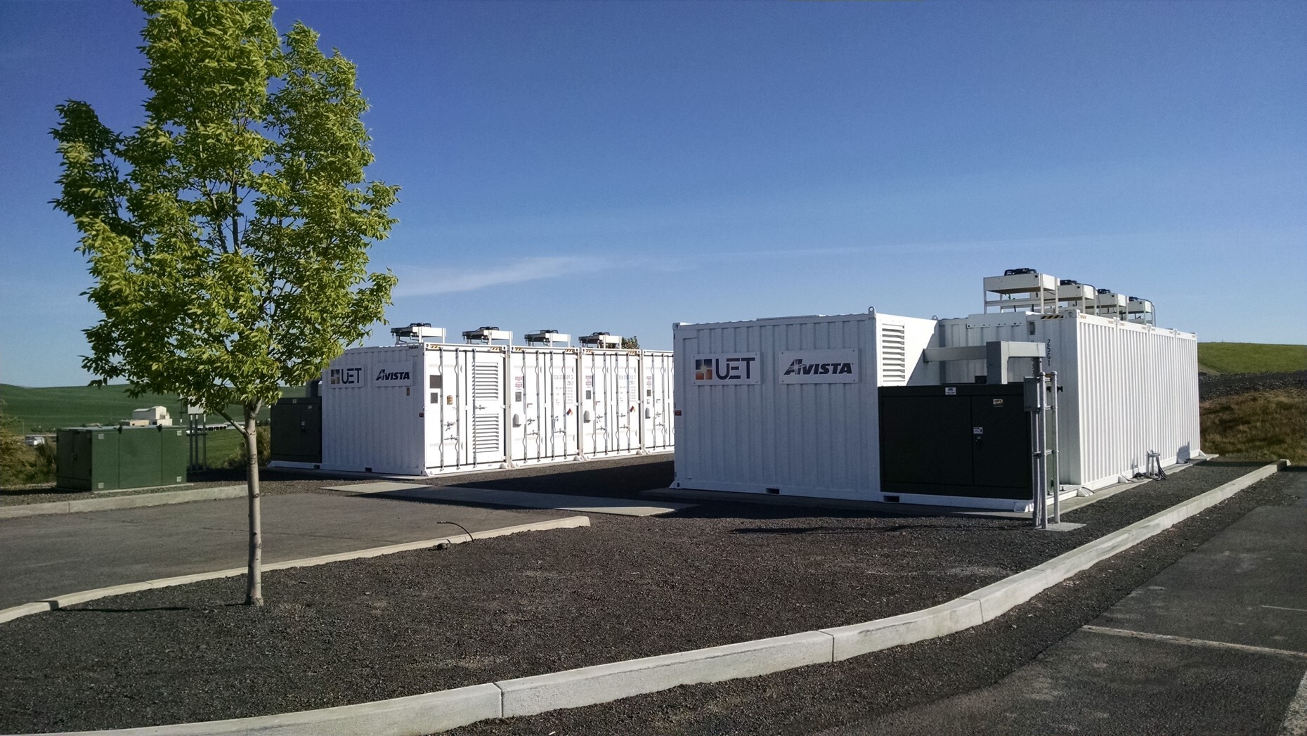 Photorealistic battery energy storage containers installed beside grid equipment.